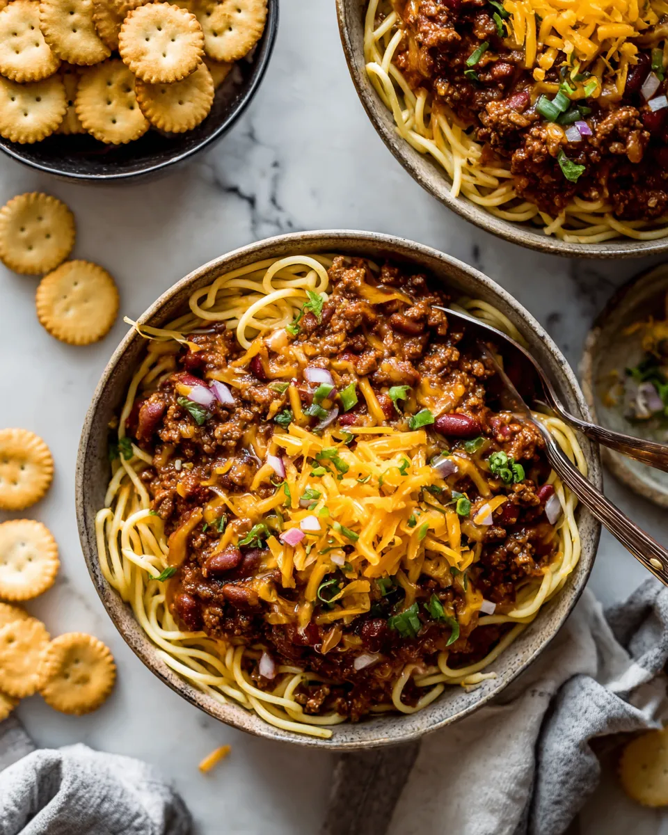 Delicious Cincinnati Chili served over spaghetti with cheese and onions, perfect for cozy gatherings and holiday meals.